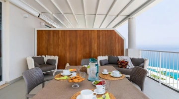 Essbereich im Freien mit Tischen und Sofas