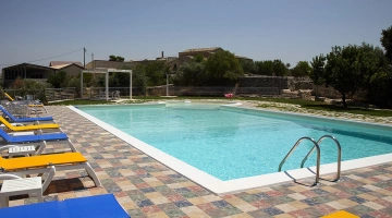 Piscina a sfioro con lettini