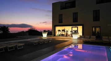 Vue nocturne de la piscine et de la salle de sport