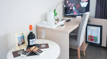 Scrivania, minibar e TV in camera