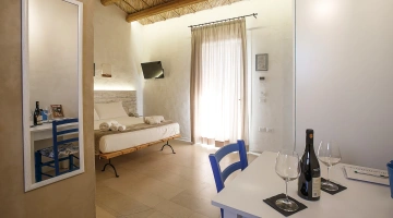Camera con letto matrimoniale, tavolo e TV