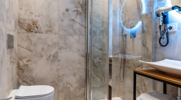 Salle de bains privée avec cabine de douche et sèche-cheveux