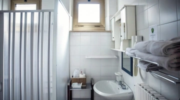 Privates Badezimmer mit Duschkabine und Wandhaartrockner