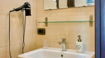 Salle de bains avec sèche-cheveux et articles de toilette gratuits