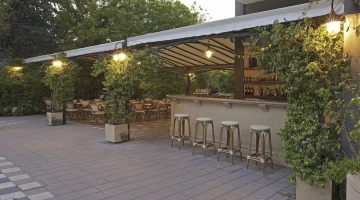 Der Poolbereich verfügt über eine ausgestattete Bar mit einer großzügigen Veranda